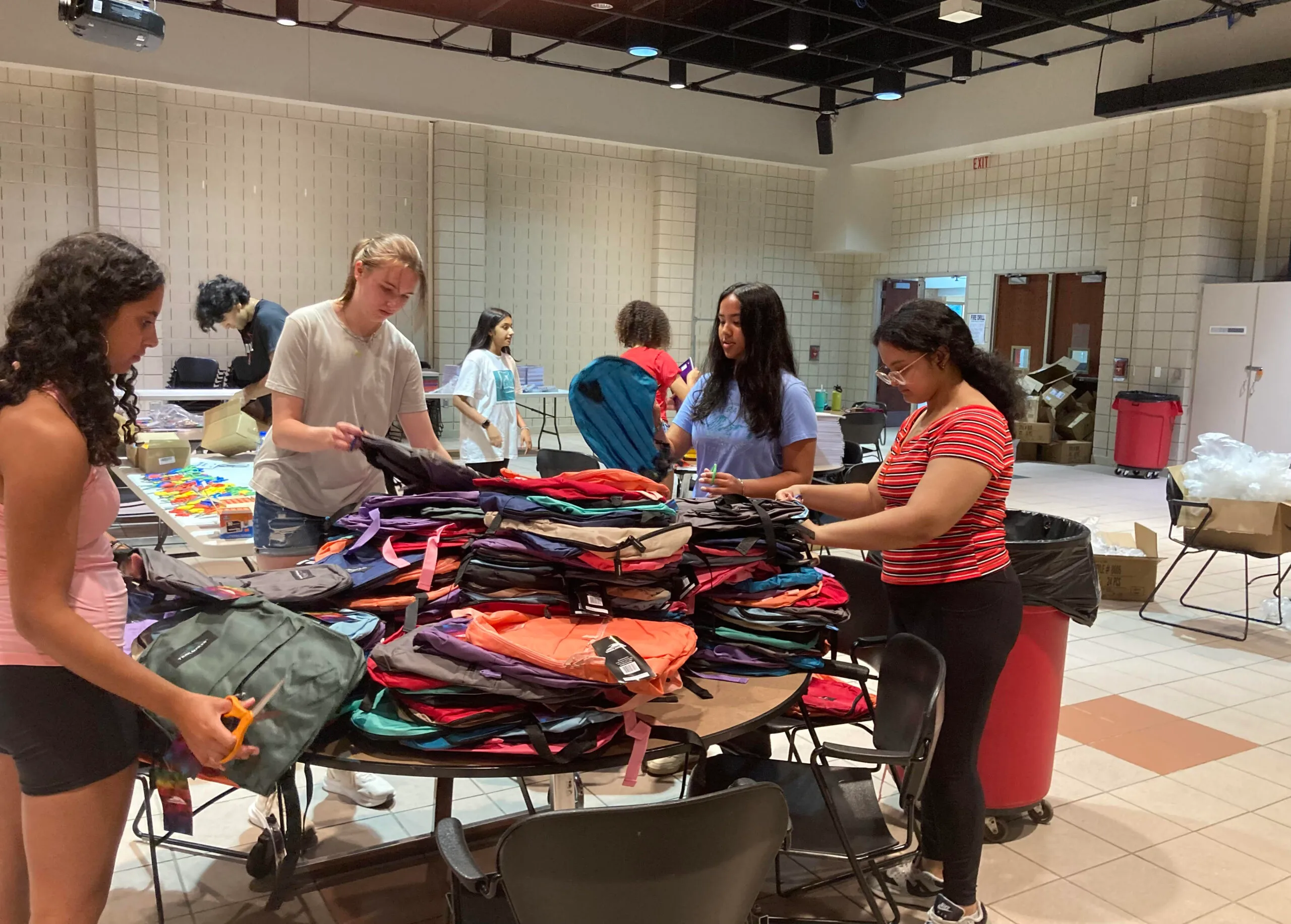 CCL-KIDS volunteers organizing hundreds of backpacks for the annual drive