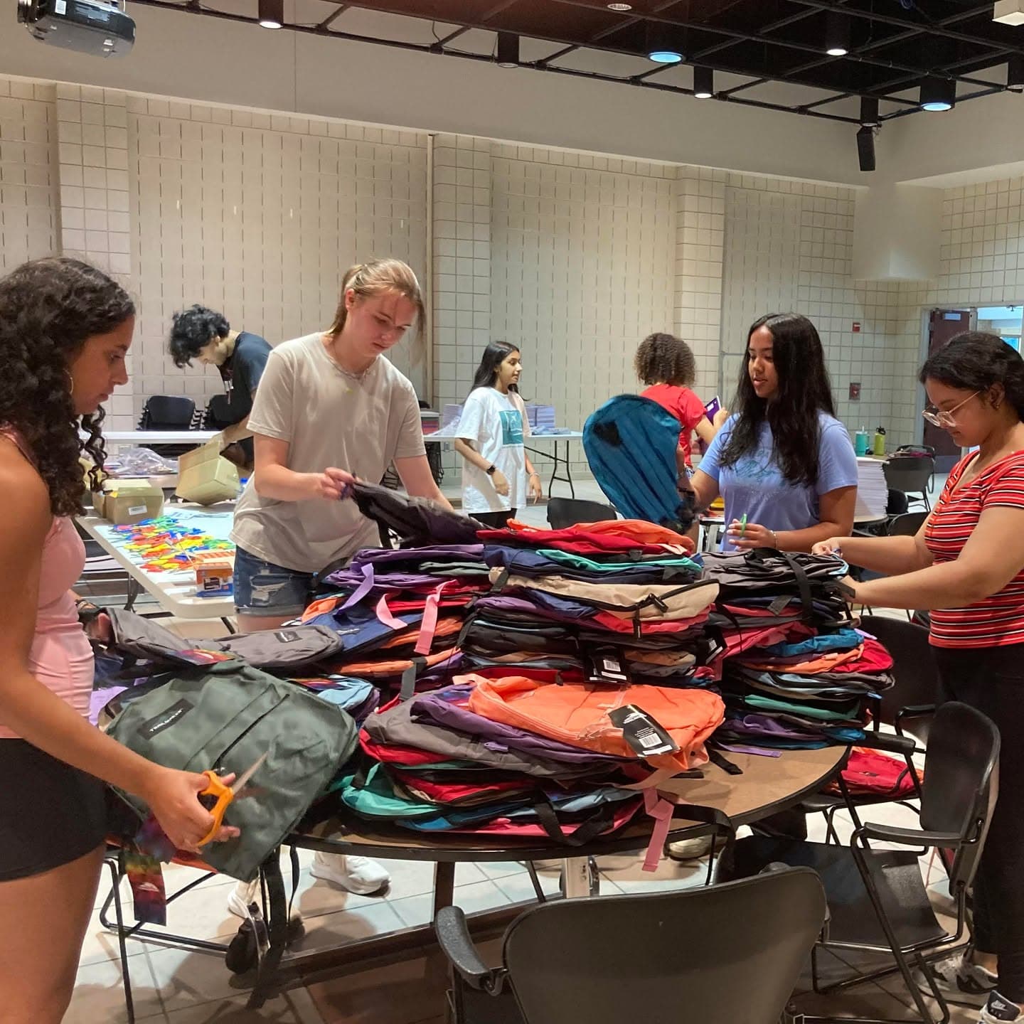 CCL-KIDS volunteers organizing backpacks for distribution